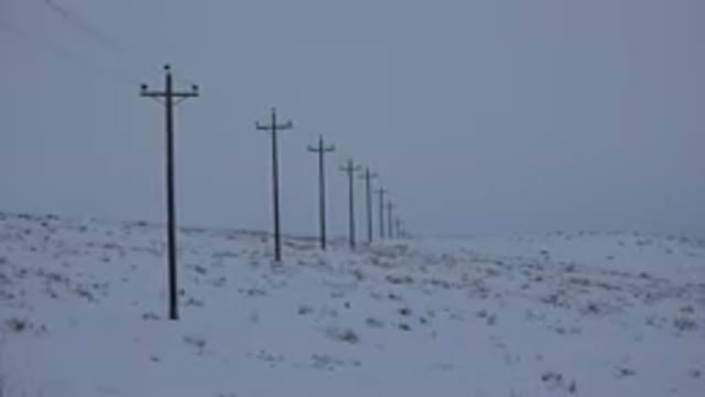 ARVADA COLORADO-2015: A Line of High Line Poles in an Empty Snow-Covered Field
