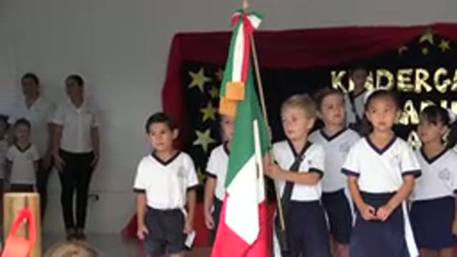 SAN JOSE DEL CABO MEXICO-2019: Kids With The White Top And Black Shorts Are Standing On Stage Holding A Flag