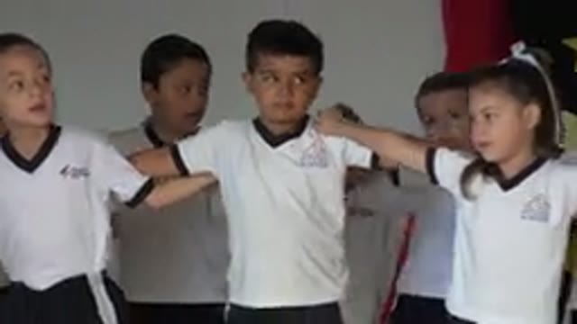 SAN JOSE DEL CABO MEXICO-2019: Kids Wearing White Shirts Walk On Stage With Linked Arms