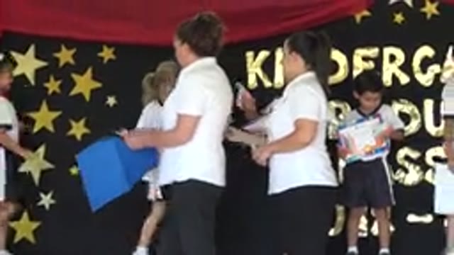SAN JOSE DEL CABO MEXICO-2019: Woman Wearing White Shirt Gives Slips Of Paper To Children