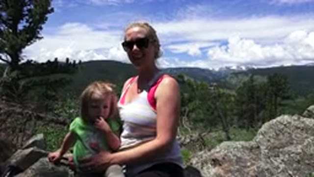 WESTMINSTER COLORADO-2016: Woman Sitting On A Rock Holding A Child In The Landscape