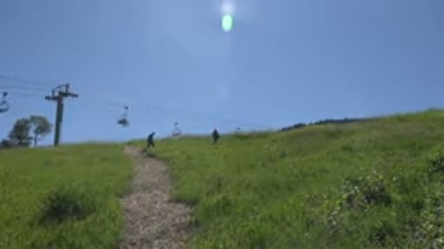 MESA COLORADO-2016: People Walking Through A Grassland With Sun And Sky