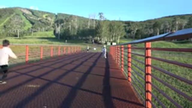 MESA COLORADO-2016: Three Little Kids Running Across A Bridge Towards A Sign