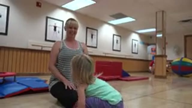 WESTMINSTER COLORADO-2016: Girl Wearing Purple Pants Picks Up Brown Ball In Gymnasium