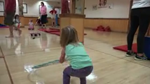WESTMINSTER COLORADO-2016: Girl Wearing Purple Pants Picks Up Green Hula Hoop In