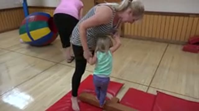WESTMINSTER COLORADO-2016: Woman in Black Tights Helps Girl in Purple Pants Balance on Beam