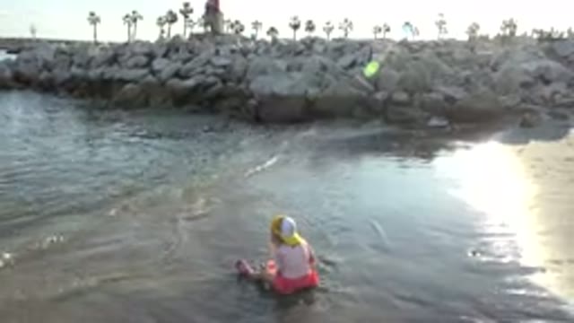 GRAND JUNCTION COLORADO-2017: Little Girl Sitting At Shore Playing In Water