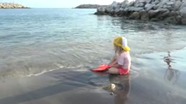 GRAND JUNCTION COLORADO-2017: Little Girl On Beach Playing In The Water And Waves