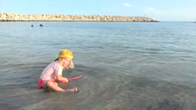 GRAND JUNCTION COLORADO-2017: Little Blonde Child in Peach Playing on Beach
