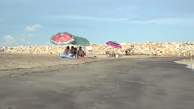 GRAND JUNCTION COLORADO-2017: Beach On A Sunny Day With Rocks Sand Sea Blue Sky