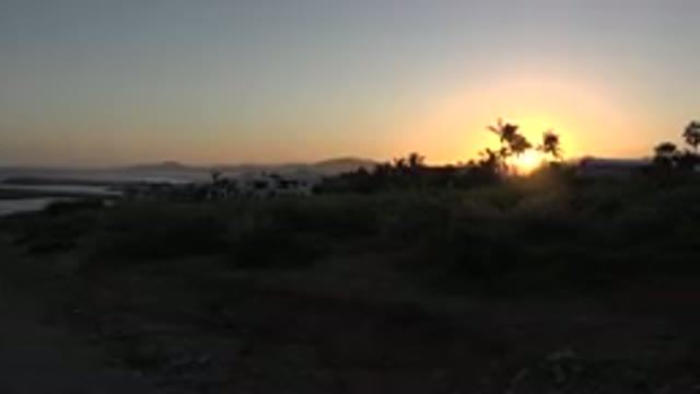 GRAND JUNCTION COLORADO-2017: Sun Setting Next To The Ocean With Trees And Hill