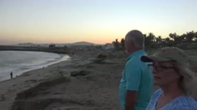 GRAND JUNCTION COLORADO-2017: Man And Woman Stand On Tan Beach Looking At Surf