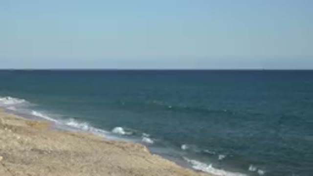 GRAND JUNCTION COLORADO-2017: Blue Ocean Waves And Tan Beach On A Bright Sunny Day