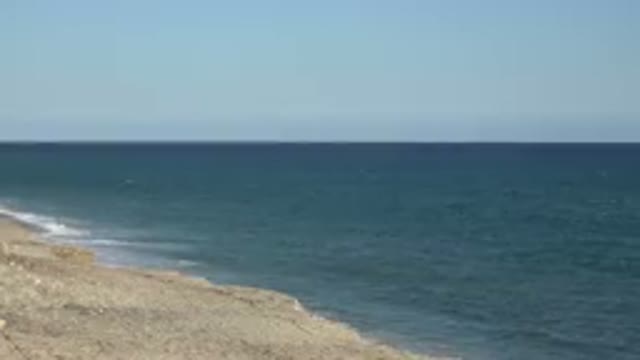 GRAND JUNCTION COLORADO-2017: Blue Ocean Water And Tan Beach On A Clear Day