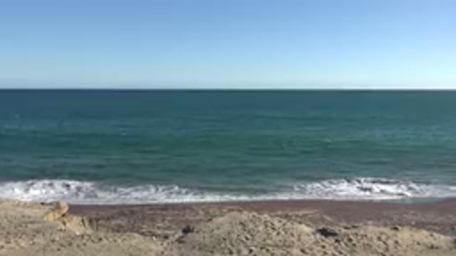 GRAND JUNCTION COLORADO-2017: Beach On A Sunny Day With Rocks Sand Sea Blue Sky