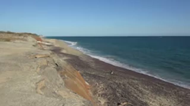 GRAND JUNCTION COLORADO-2017: Beach On A Sunny Day With Rocks Sand Sea Blue Sky