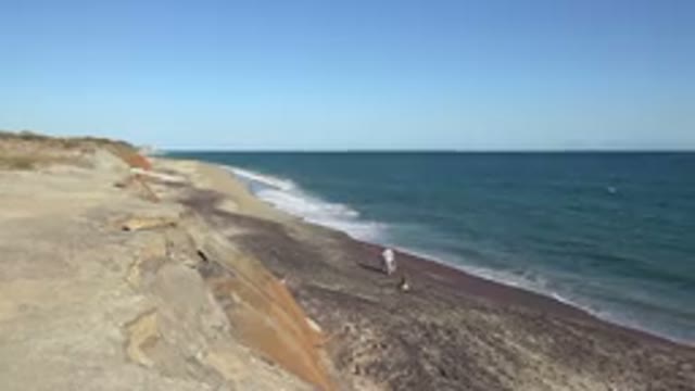 GRAND JUNCTION COLORADO-2017: Man In White Walks Along Narrow Beach During