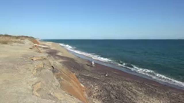 GRAND JUNCTION COLORADO-2017: Person Walking on Shore With Sand and Waves