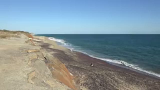 GRAND JUNCTION COLORADO-2017: Rocky Beach on a Sunny Day with Ocean Waves and Sand