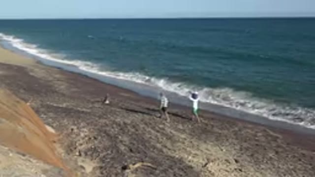 GRAND JUNCTION COLORADO-2017: Beach On A Sunny Day With Rocks Sand Sea Blue Sky
