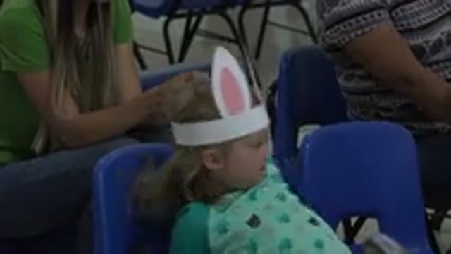 CABO SAN LUCAS MEXICO-2019: Girl Wearing Green Shirt And White Rabbit Ears Sits On Blue Chair