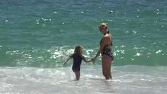 CABO SAN LUCAS MEXICO-2019: Child Playing On The Beach With Her Mother As Waves