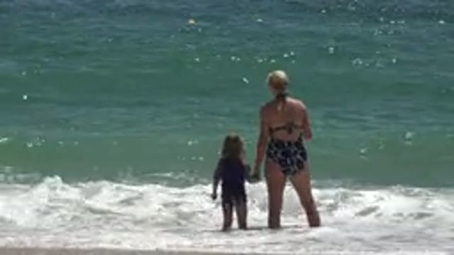 CABO SAN LUCAS MEXICO-2019: Mother And Daughter Playing With The Waves At The Beach