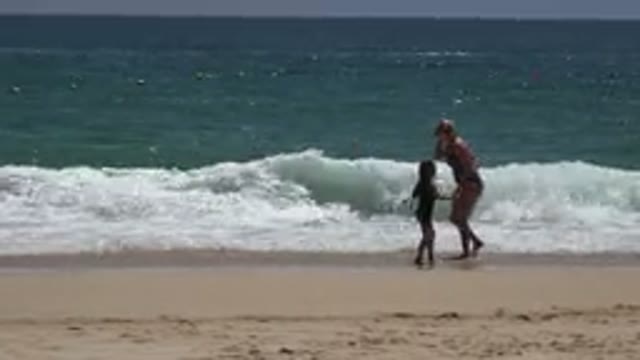 CABO SAN LUCAS MEXICO-2019: Woman and Child Playing at the Beach with Waves and Sun