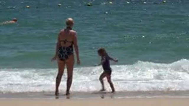 CABO SAN LUCAS MEXICO-2019: A Woman And Her Daughter Playing At The Water's Edge