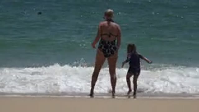 CABO SAN LUCAS MEXICO-2019: Woman In A Black And White Swimsuit With A Child On