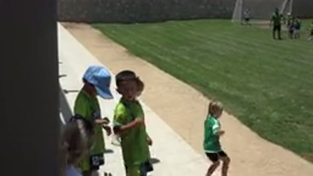 CABO SAN LUCAS MEXICO-2019: Kids Wearing Green Shirts Run Onto Green Grass Field