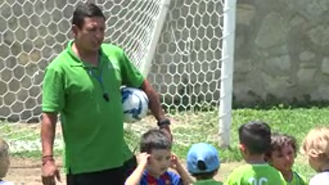 CABO SAN LUCAS MEXICO-2019: Coach In Green Shirt Instructs Kids Soccer Team On Field