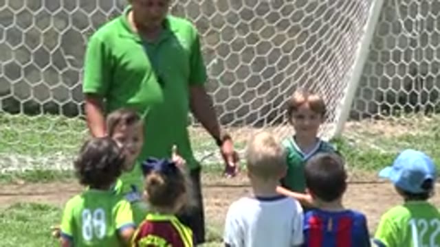 CABO SAN LUCAS MEXICO-2019: A Group Of Young Kids In Green Uniforms Huddled With Coach