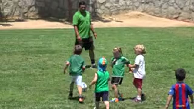 CABO SAN LUCAS MEXICO-2019: Small Children In Green Football Uniforms Play Near