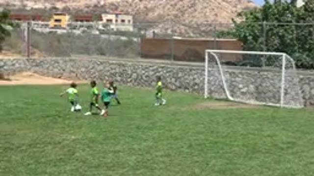 CABO SAN LUCAS MEXICO-2019: Kids Playing Soccer On Green Grass On A Bright Sunny Day