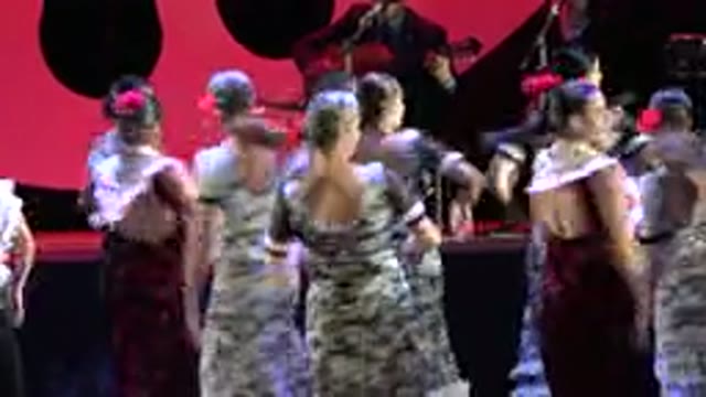 CABO SAN LUCAS MEXICO-2019: Women Wearing Grey Dresses Dance With Woman Wearing Red Dress