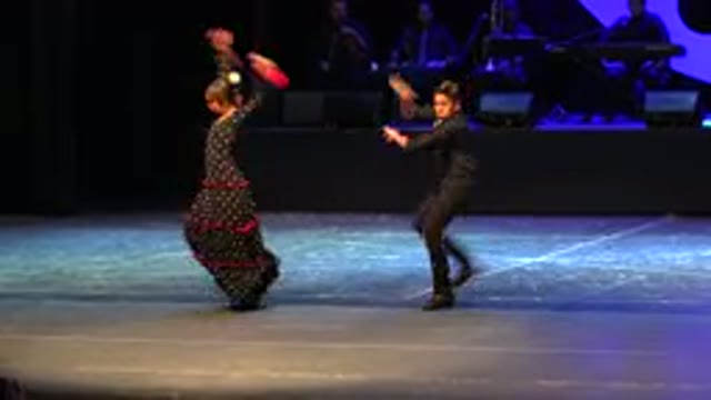 CABO SAN LUCAS MEXICO-2019: A Man And Women In Red And Black Dresses Are Dancing