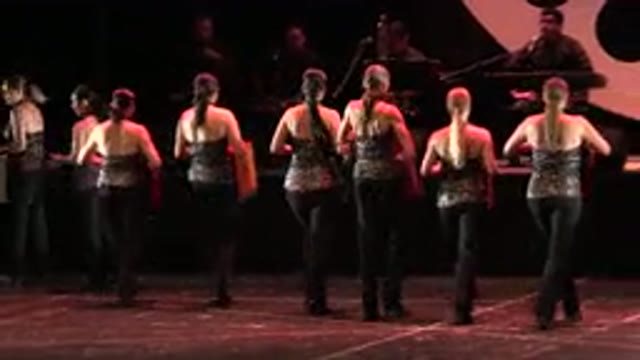 CABO SAN LUCAS MEXICO-2019: A Line Of Women Dancers Carrying Props Around A Stage