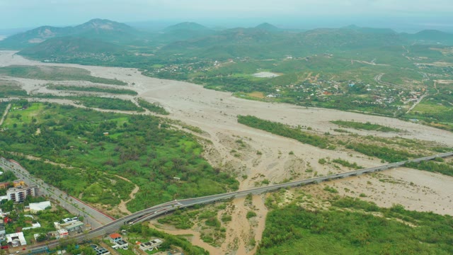 SAN JOSE DEL CABO BCS MEXICO-2021: Muddy River Flowing Past Bridge and Greenery