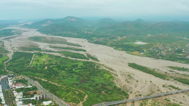 SAN JOSE DEL CABO BCS MEXICO-2021: Muddy River Flowing Through Green Valley and Urban Area