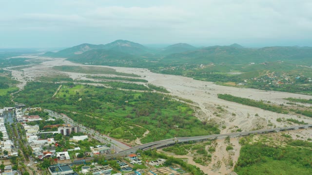 SAN JOSE DEL CABO BCS MEXICO-2021: Muddy River Flowing Under Bridge with Lush Banks