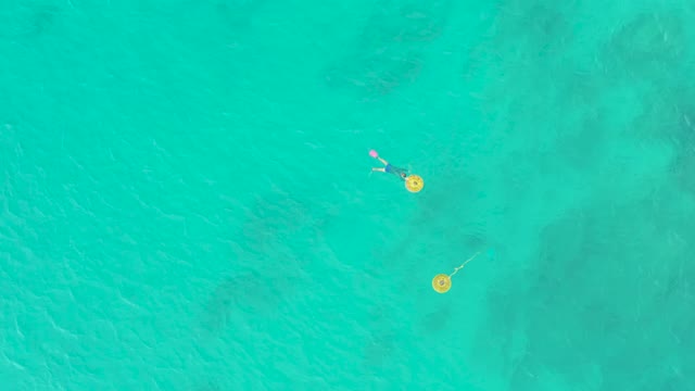 LAGUNA BEACH LOS CABOS BCS MEXICO-2021: Swimmer with Floatie near Yellow Buoys in Turquoise Water
