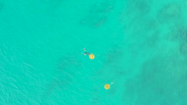 LAGUNA BEACH LOS CABOS BCS MEXICO-2021: Person Floating on Yellow Float in Clear Turquoise Water