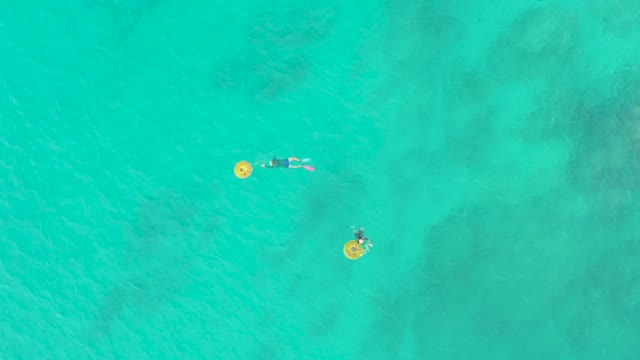 LAGUNA BEACH LOS CABOS BCS MEXICO-2021: Two Swimmers with Yellow Floats Moving in Turquoise Water