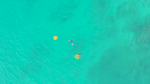 LAGUNA BEACH LOS CABOS BCS MEXICO-2021: Two Swimmers with Yellow Float Rings in Turquoise Water