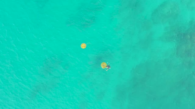 LAGUNA BEACH LOS CABOS BCS MEXICO-2021: People Swimming with Yellow Floats in Turquoise Water