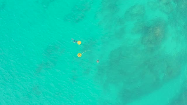 LAGUNA BEACH LOS CABOS BCS MEXICO-2021: People Floating with Yellow Buoys in Shallow Turquoise Water