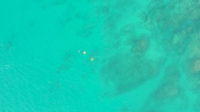 LAGUNA BEACH LOS CABOS BCS MEXICO-2021: Swimmers with Yellow Floats in Clear Ocean Water