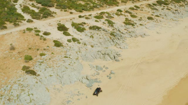 LAGUNA BEACH LOS CABOS BCS MEXICO-2021: SUV Traversing Sandy and Rocky Desert Landscape