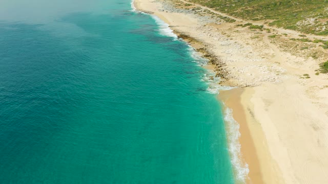 LAGUNA BEACH LOS CABOS BCS MEXICO-2021: Gentle Ocean Waves on Sandy Beach with Rocky Shore
